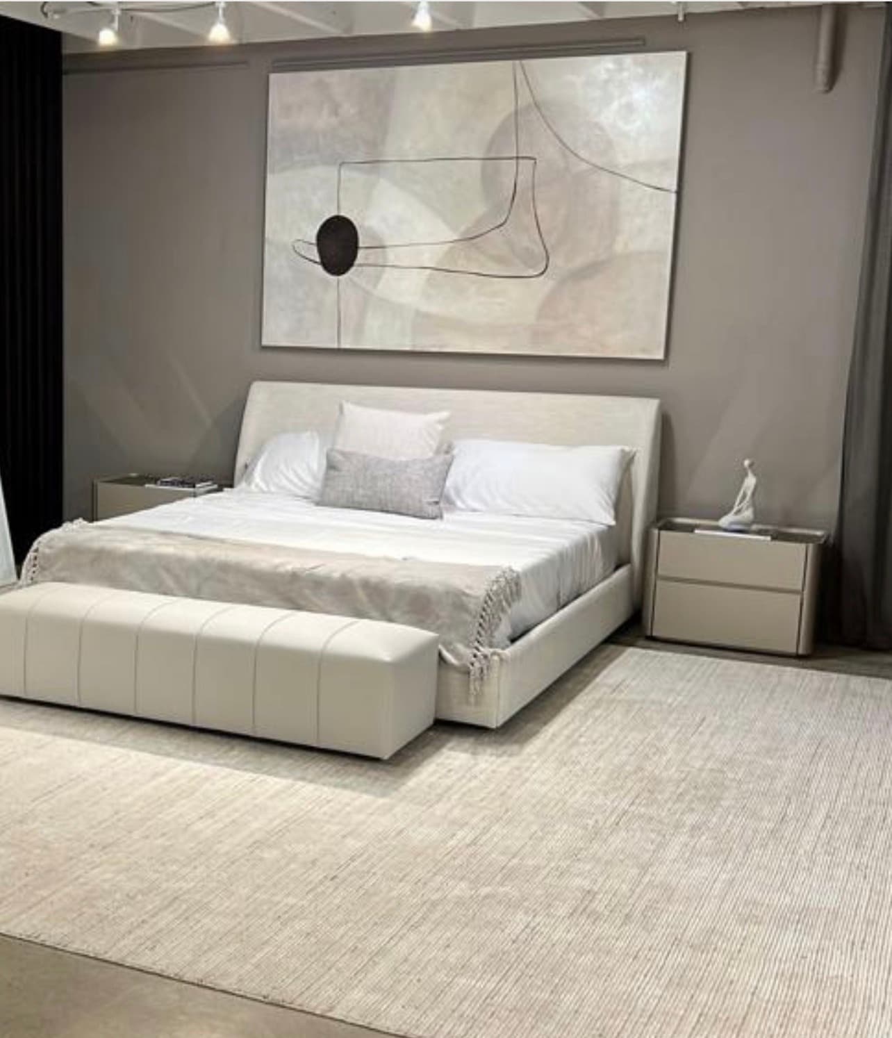 Cama estofada Liverpool em exposição na loja conceito Park Sul, com recamier ao pé e quadro na parede