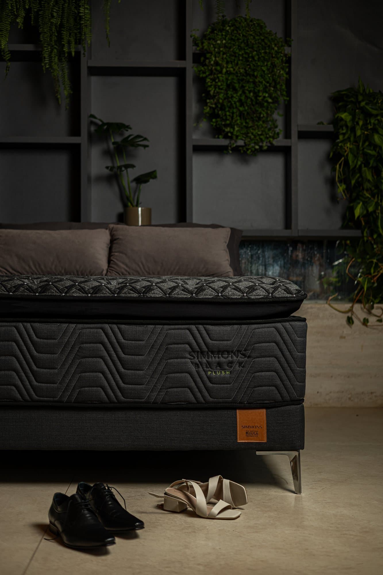 Colchão Simmons Black Plush com sapatos de um casal no chão, ao pé da cama