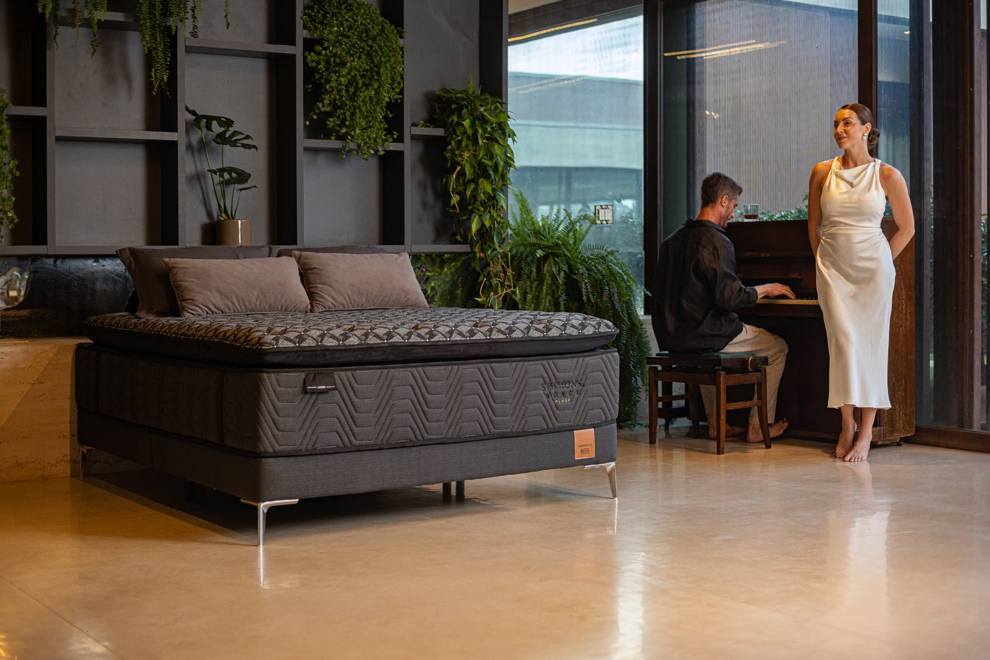 Showroom Simmons com colchão Black Plush, plantas e piano