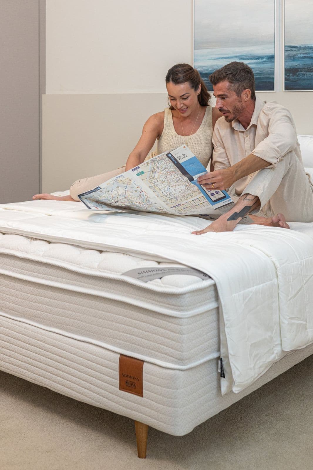 Casal sentado na cama Simmons Geocities olhando um tablet