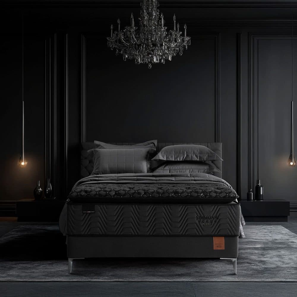 Quarto escuro com paredes em boiserie preta e lustre de cristal, com um conjunto Simmons Black Plush ao centro